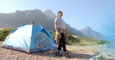 Yürüyüşe hazırlanan yürüyüşçü çadırdan çıkıp sağlık ölçümlerini gösteren eklem simgelerini etkinleştiriyor. Macera, fitness, vahşi doğa, açık hava, keşif, sağlık, motivasyon