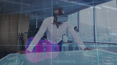 VR kulaklığı yerleştiren bir adam, dönen teknoloji hologramına iş arkadaşının izlediği detayları inceliyor. Sanal gerçeklik, holografi, yenilik, işbirliği, dijital arayüz, geleceksel, teknoloji