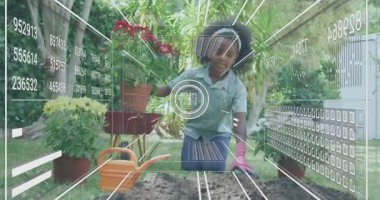 Kırmızı saksı toplayan ve AR teknolojisini etkinleştiren bir çocuk, tohum ekerken toprak sağlığını tarıyor. Bahçıvanlık, teknoloji, eğitim, açık hava, yenilik, gençlik, doğa