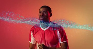 Atlet hala mavi parçacıkları takip ediyor. Çerçeveye giriyor ve spor gösterisine gidiyor. Dinamik, geleceksel, hareket, atlet, enerji, dijital, performans