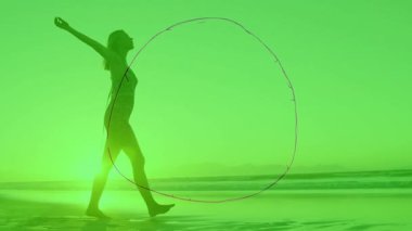 Sahilde yalınayak yürüyen bir kadın. Eğitimsel dünyanın gölgesinde beliriyor. Birlik olduğunu gösteriyor. Yerleşim, uyum, dinginlik, keşif, bağlantı, farkındalık, çevre