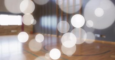 Yüzen ışıklar eşliğinde spor salonu kameraları çalışıyor ve takım arkadaşları antrenman için topa giriyorlar. Sporcular, takım çalışması, spor giyim, enerjik, dinamik, geometrik, genç