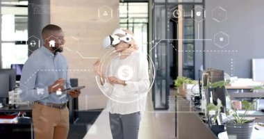 Erkek meslektaşım, veri analizi için finans simgeleri ortaya çıkarken, VR kulaklığını ayarlayan kadına yardım ediyor. Teknoloji, işbirliği, yenilik, dijital, fütüristik, arayüz, çalışma alanı