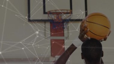 Basketbolcunun yukarıdan top kaldırması analitikleri aynı hizaya getiriyor ve basket atıyor. Sporcu, spor, fitness, motion, technology, takım çalışması, yoğunluk