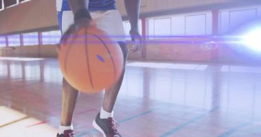 Basketbolcu top sürmeye, karşıya geçmeye ve mercek altında şut atmaya başladı. Atletizm, spor, dinamik, kararlılık, performans, spor salonu, enerji