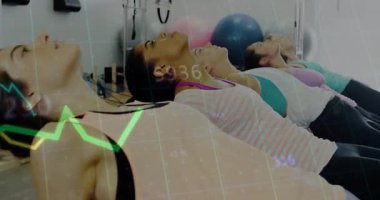 Beş kadın pilates yaparken ayak parmaklıklarına basıyor ve duruş için finansal grafiklerle arkasına yaslanıyor. Spor, sağlık, egzersiz, hareket, eğitim, sağlık, esneme