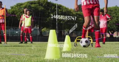 Futbolcu futbol antrenmanında dijital ölçümler rehberlik ederken külahlarda top sürmeye başlıyor. Atletik, antrenman, spor, çeviklik, takım çalışması, açık hava, performans