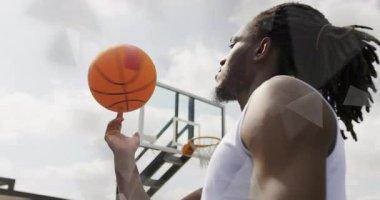 Oyuncu yukarı doğru fiske vuruyor ve basketbol potanın altında dönüyor. Eğitim için spin kontrolü öğretiyor. Dinamik, spor, performans, şehir, odaklanma, atletizm, eğitim