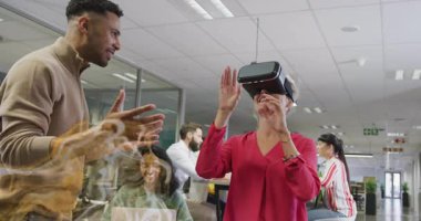Erkek iş arkadaşının el kol hareketi yapması, rehberlik etmesi, VR kulaklığını kaldırması, teknik demo için girdap oluşturması. Teknoloji, yenilik, işbirliği, fütüristik, dijital, çalışma alanı, dalgın