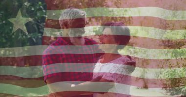 Kadın ve erkek karşılıklı gülümsüyor ve güneşli bahçe yolunda sarılıp sağlığa dikkat çekiyor. Şefkat, arkadaşlık, açık hava, doğal, samimi, dinginlik, samimiyet