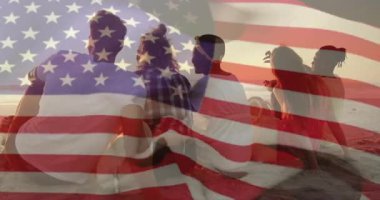 Yarı saydam Amerikan bayrağının yer aldığı seyahat görüntüleri soluyor, arkadaşlar kum temizliyor, gün batımını seyrediyor. Sahil şeridi, yoldaşlık, boş zaman, açık hava, sükunet, sıcak tonlu, bağlı