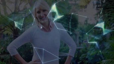 Gülümseyen ve parlayan ağ şekilleri oluşturan bir kadın avuç içi haritalama teknolojisinin üzerinde dönen bir dünyaya dönüşüyor. Teknoloji, yenilik, bağlantı, dijital, fütüristik, strateji, çevre