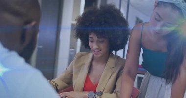 İş arkadaşları dokümanları kaydırıyor, sayfaları çeviriyor, detayları gösteriyor ve anlaşmanın ilerlemesini tartışıyorlar. İşbirliği, takım çalışması, profesyonel, tartışma, ofis, planlama, strateji