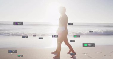 Güneşli sahil boyunca yürüyen bir çift sosyal medya simgeleri oluşturarak nişan büyümesini gösteriyor. Plaj, yaz, siluet, dinginlik, dijital, etkileşim, yaşam tarzı