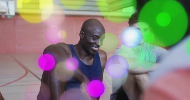 İki fitness partneri antrenör yorumları duyuyor ve spor salonunda yer değiştiriyor, bokeh daireler çiziyor. Takım arkadaşları, yoldaşlık, sağlık, aktif, motive edici, enerjik, takım çalışması.