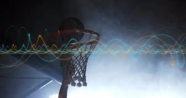 Basketbolu kavrayan sporcu, dalgalanan nabız atarken ağda smaç basıyor. Dinamik, atletik, fütürist, yoğun, hareket, enerji, performans