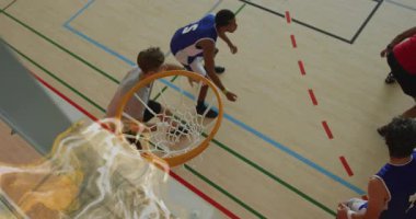 Top çerçeveye giriyor, smaç basıyor, potaya doğru sıçrıyor ve çemberin etrafında dönen efektler var. Atletizm, rekabet, sportmenlik, aksiyon, enerjik, dinamik, takım çalışması