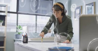 Tasarımcı pusulayı yakalıyor ve veri simgeleri sürüklenen kağıt planlama üzerine kusursuz daireler çiziyor. Yaratıcı, profesyonel, minimalist, yenilikçi, hassasiyet, çalışma alanı, kentsel