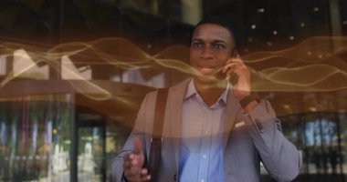 İş adamı akıllı telefon kaldırıyor ve dış girişin yerini doğrularken dalga formlarını etkinleştiriyor. Profesyonel, iletişim, kentsel, teknoloji, kurumsal, modern, yaşam tarzı