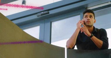 Adam atriyum korkuluklardan akıllı telefon görüşmesi yapıyor. Renkli verileri karıştırıyor. Sinyal bekliyor. Teknoloji, fütürizm, dijital, bağlantı, modernizm, profesyonel, kentsel