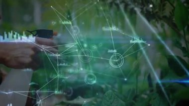Bahçıvan, bitkileri ilaçlıyor. Analitik teknoloji gerçek zamanlı bitki verisi atıyor. Bahçecilik, dijital, teknoloji, eko, doğa, yenilik, sürdürülebilirlik