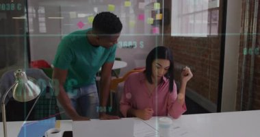 İş arkadaşları ofis masasına eğilip notlar yazarken belgeleri gösteriyorlar ve okları canlandırıyorlar. İşbirliği, takım çalışması, ofis, profesyonel, beyin fırtınası, planlama, tartışma