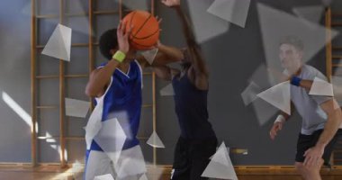 Mavi üniformalı oyuncu defans oyuncusunun arkasından dönüyor. Kollarını kaldırıyor. Sayı yapmak için potaya doğru süzülüyor. Atletizm, takım çalışması, rekabet, yoğunluk, spor, hareket, kentsel