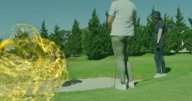 Golfçü sığınakta sallanıyor altın parçacıkları harekete geçiriyor, atış yörüngesini parlaklaştırıyor. Spor, eğlence, açık hava, etkinlik, zarafet, hareket, doğa.