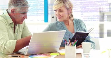 Kadın not alırken, adam dizüstü bilgisayarı işaret ederek teknik arayüze animasyon kodları yüklüyor. İşbirliği, takım çalışması, ofis, iletişim, yenilik, beyin fırtınası, profesyonel