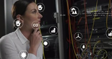 Bilgi işleme teknisyeni çenesini tutuyor sonra da ölçümleri izlemek için karbondioksit ve enerji simgelerine dokunuyor. Teknoloji, veri merkezi, dijital arayüz, çevresel izleme, profesyonel, yenilik, gelecekçi