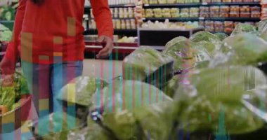 Marul almaya gelen market alışverişçisi sepete koymadan önce dönen kafalar kontrol ediyor. Taze ürün, süpermarket, alışveriş, sağlıklı beslenme, ticaret, renkli, yaşam tarzı