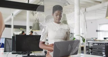 İş yerinde dizüstü bilgisayarda yazı yazan ve dönen dünyaya evrimleşen dünya haritasını etkinleştiren bir iş arkadaşı. İşbirliği, yenilik, dijital, ağ oluşturma, üretkenlik, fütürist, kurumsal