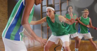 Defans pozisyonu alıyor ve basketbol antrenmanı için turuncu topla salya akıtıyor. Atletik, takım çalışması, yoğunluk, spor, çeviklik, motivasyon, eğitim