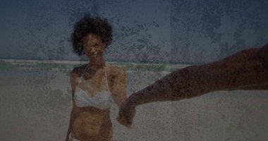 Beyaz bikinili gülümseyen kadın kumlu sahilde partnerini tutuyor, dalga ufku, fotokopi uzayı. Plaj, romantizm, yaz, dinginlik, arkadaşlık, eğlence, yaşam tarzı.