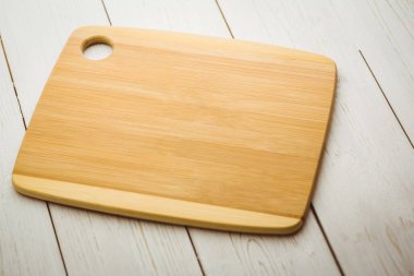 Close-up of chopping board on white wooden flooring