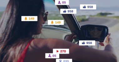 Aynalı Hintli kadın, güneş gözlüklü, sahil yolunda medya simgeleriyle sürüyor, kopyalama alanı. Macera, seyahat, yaşam tarzı, otomotiv, şehir, manzara, dinamik