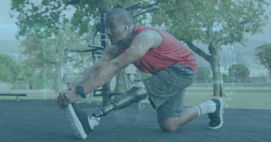 Leaning athlete wearing sportswear extending right leg on park rubber surface, with prosthetic leg. Athlete, fitness, rehabilitation, outdoor, strength, activity, endurance