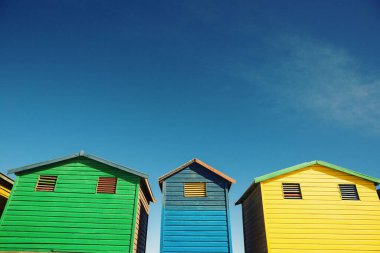 Low angle view of colorful beach hut against blue sky during sunny day