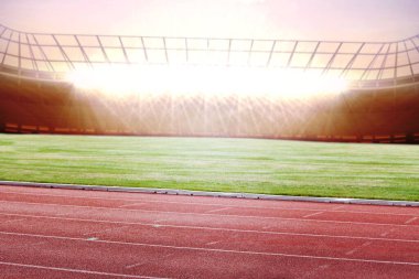 Boş atletizm stadyumu kırmızı pist, saha ve projektörlerin altında düz bir şekilde duruyor. Spor kompleksi, açık alan, rekabet, atletik, fitness, minimalist, altyapı