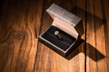 Ahşap zeminde mücevher kutusunda yüzüğün yüksek açılı görüntüsü