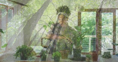 Eğik bitki meraklısı dinlenme çenesi ve güneşli odada saksı bitkileri ve saç bandıyla kameraya bakıyor. Botanik, bahçıvanlık, doğal ışık, iç tasarım, sağlık, sürdürülebilir, yaşam tarzı