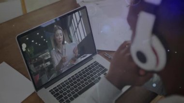 Uzaktan kumandalı teknoloji toplantısında erkek kulaklığı aktifleştiren kağıtları inceleyen kadın olarak ayarlıyor. Teknoloji, çalışma alanı, işbirliği, dijital ağ, profesyonel, modern, iletişim