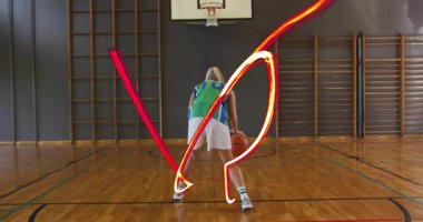 Düşük duruş oyuncusu salya akıttıktan sonra sporda kırmızı-turuncu ışık izleriyle sayı yapmak için şut atıyor. Atletizm, hareket, dinamik, enerji, rekabet, canlılık, beceri