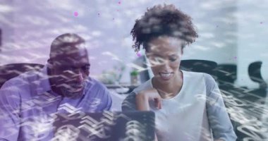 Kadın dizüstü bilgisayarı işaret edip, veri akışlarını açıklarken ölçümleri tartışan bir çift olarak sürükleniyordu. İşbirliği, takım çalışması, iletişim, yenilik, dijital, modern, ofis