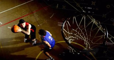 Sayı yapan oyuncu defans baskısı altında basket atıyor atlıyor ve sayı yapmak için topu serbest bırakıyor. Sporcular, rekabet, dinamik, aksiyon, sportmenlik, yoğunluk, çeviklik