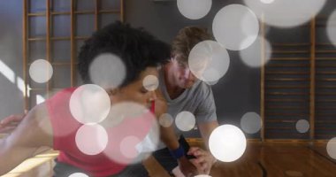 Kırmızı formalı oyuncu basketbola çömelmiş, salyalarını akıtıyor ve basket savunmasına doğru sürüyor. Atletik, rekabet, yoğunluk, çeviklik, hareket, spor, eğitim