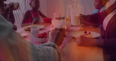 Anne sürahiyi kaldırıyor, babaya doğru kayıyor çocuklar kahvaltıya başlarken fincana dökülüyor. Aile, kahvaltı, aile içi, beslenme, birliktelik, erdem, yaşam tarzı.