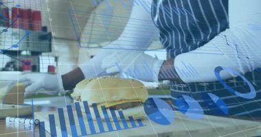 Hamburgeri kaldırırken ve çizgi çizelgelerle patates kızartması yerken mutfak tabağı takibi yaparken. Mutfak, konukseverlik, sunum, profesyonel, beslenme, tazelik, verimlilik