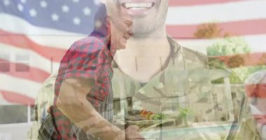 Asker portresi, yemek servisinde gaziyi onurlandırırken Amerikan bayrağı altında ızgara şiş pişirirken soluyor. Vatanseverlik, aile, açık hava, kutlama, boş zaman, yaz, toplum