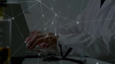 Laboratuvarda periyodik cetvel üzerinde düşünürken dizüstü bilgisayarda yazan ve veri örtüsünü etkinleştiren kıdemli bilim adamı. Araştırma, yenilik, teknoloji, veri, analiz, bilim, laboratuvar